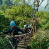 Ziplining through the jungle in Thailand above rainforest canopy, rivers, and mountain scenery