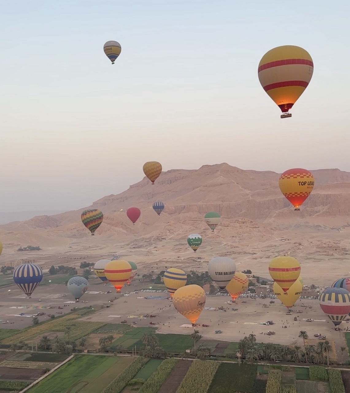Hot air balloon flying over Luxor at sunrise, with views of the Nile River, ancient temples, and the Valley of the Kings in Egypt.