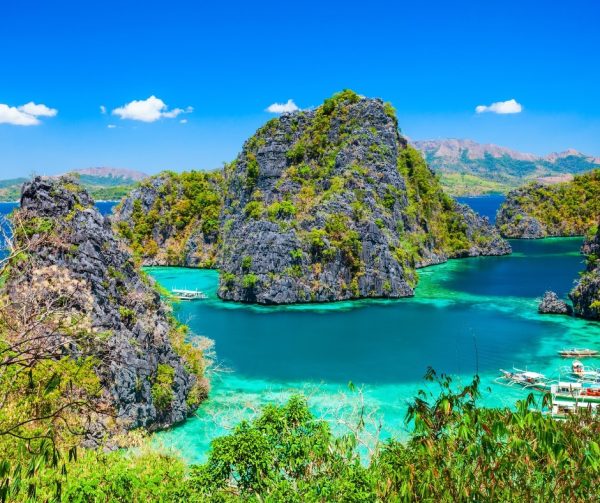 Crystal-clear Kayangan Lake in Coron, Philippines surrounded by limestone cliffs.