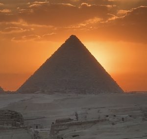 View of the Great Pyramids of Giza at sunset on a rooftop.