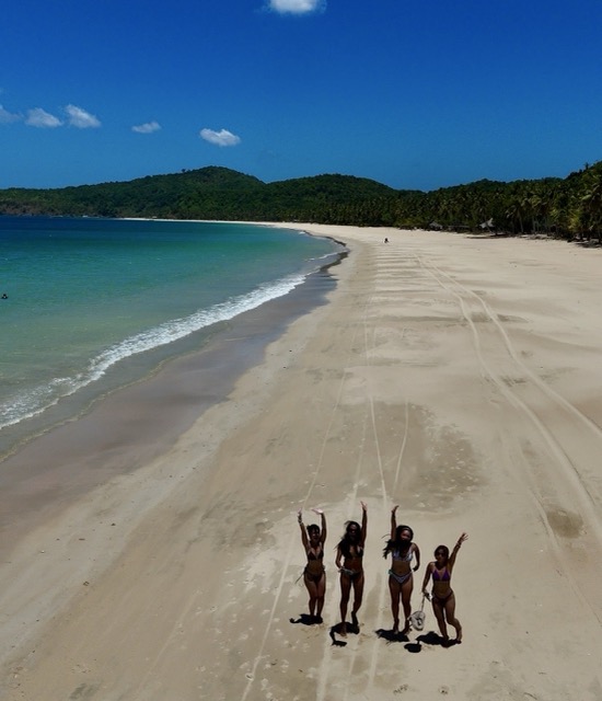 Travelers walking along Nacpan Beach in El Nido, Philippines.