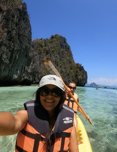 Two girls kayaking through a secret lagoon in Palawan, Philippines.