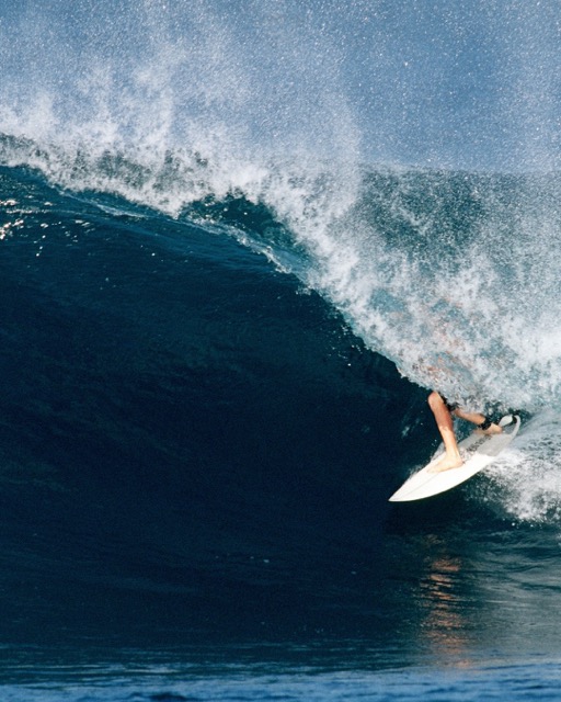 Surfer riding a wave in Siargao, Philippines.