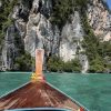 Island hopping by boat between tropical islands with turquoise water in Thailand