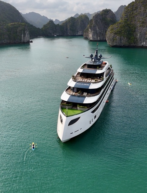 Luxury Halong Bay cruise sailing past limestone karsts in Vietnam at sunrise