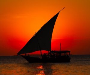Zanzibar sunset dhow cruise traditional wooden boat Indian Ocean golden sky
