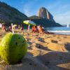 Tropical beach in Brazil with palm trees, coconut water stand, and clear blue ocean as part of a Brazil group travel itinerary experience.