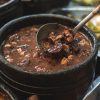 Traditional Brazilian feijoada dish served with rice, beans, orange slices, and farofa, part of a Brazil group travel experience in Rio de Janeiro.