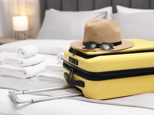 Premium travel luggage and luxury gear placed on a boutique hotel bed in a beautiful international destination