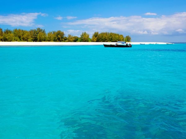 Crystal-clear turquoise water and vibrant coral reef around Mnemba Island during a Gagago marine tour in Zanzibar.