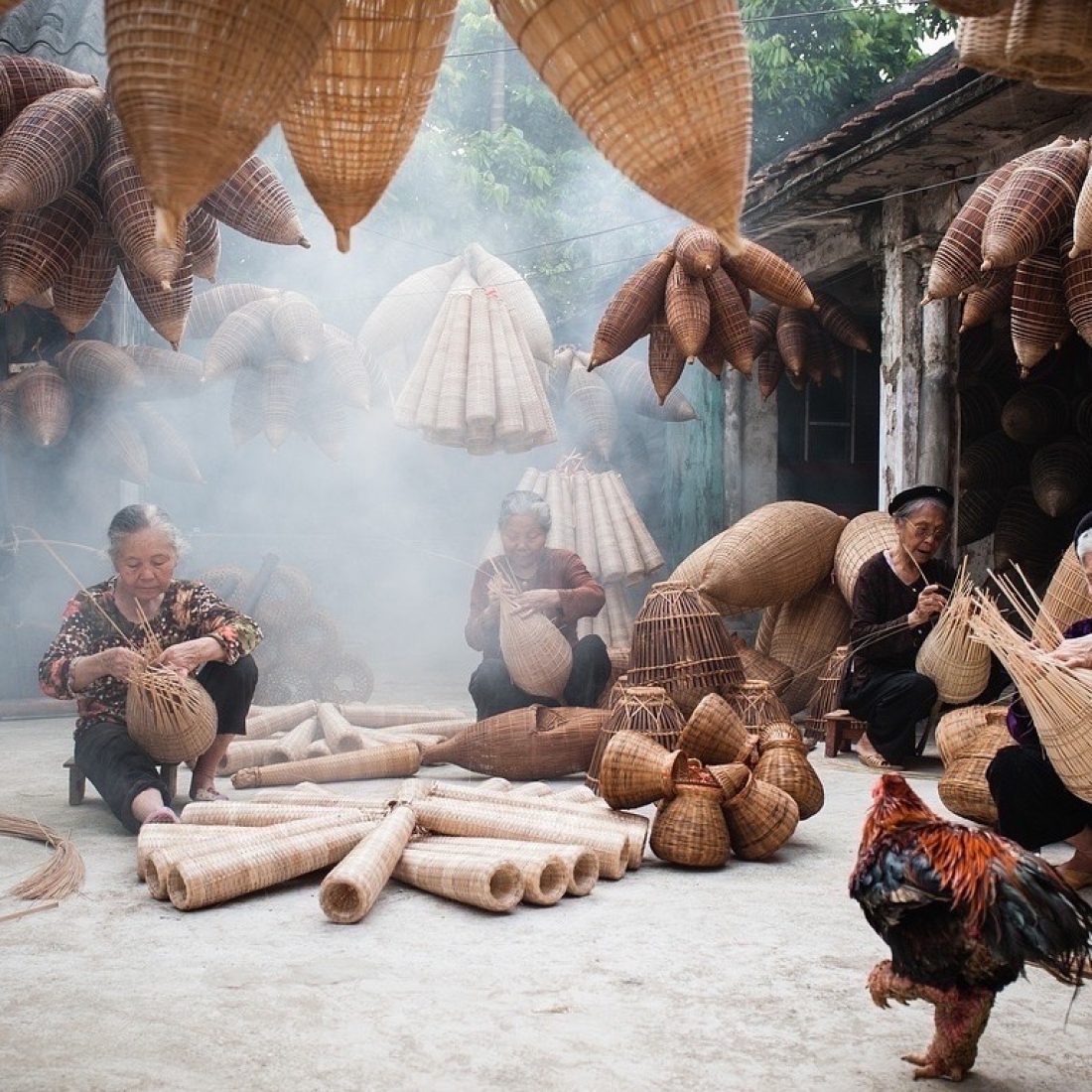 Local women weaving traditional bamboo fish baskets in a village near Hanoi, Vietnam