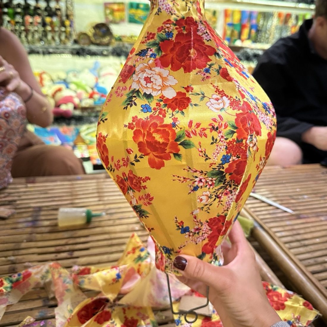 Traveler crafting colorful lanterns during a lantern-making class in Hoi An, Vietnam