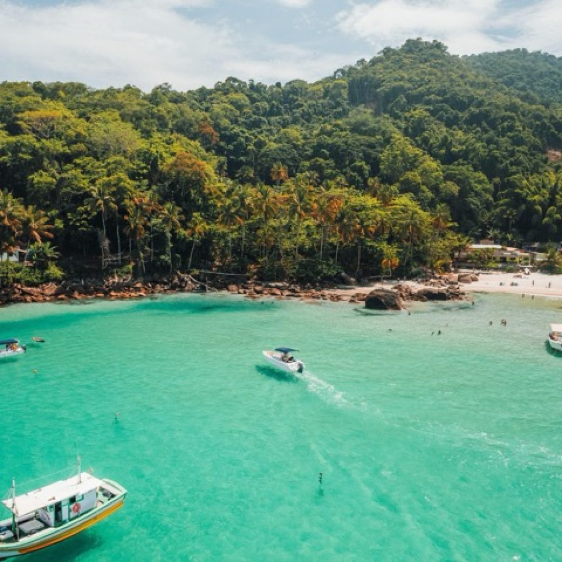 Travelers enjoying crystal-clear waters and tropical beaches in Ilha Grande, Brazil during a Gagago group trip