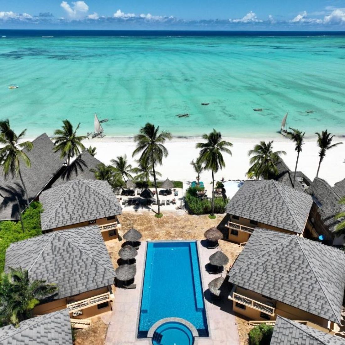 Luxury oceanfront hotel pool and lounge deck overlooking Paje Beach in Zanzibar.