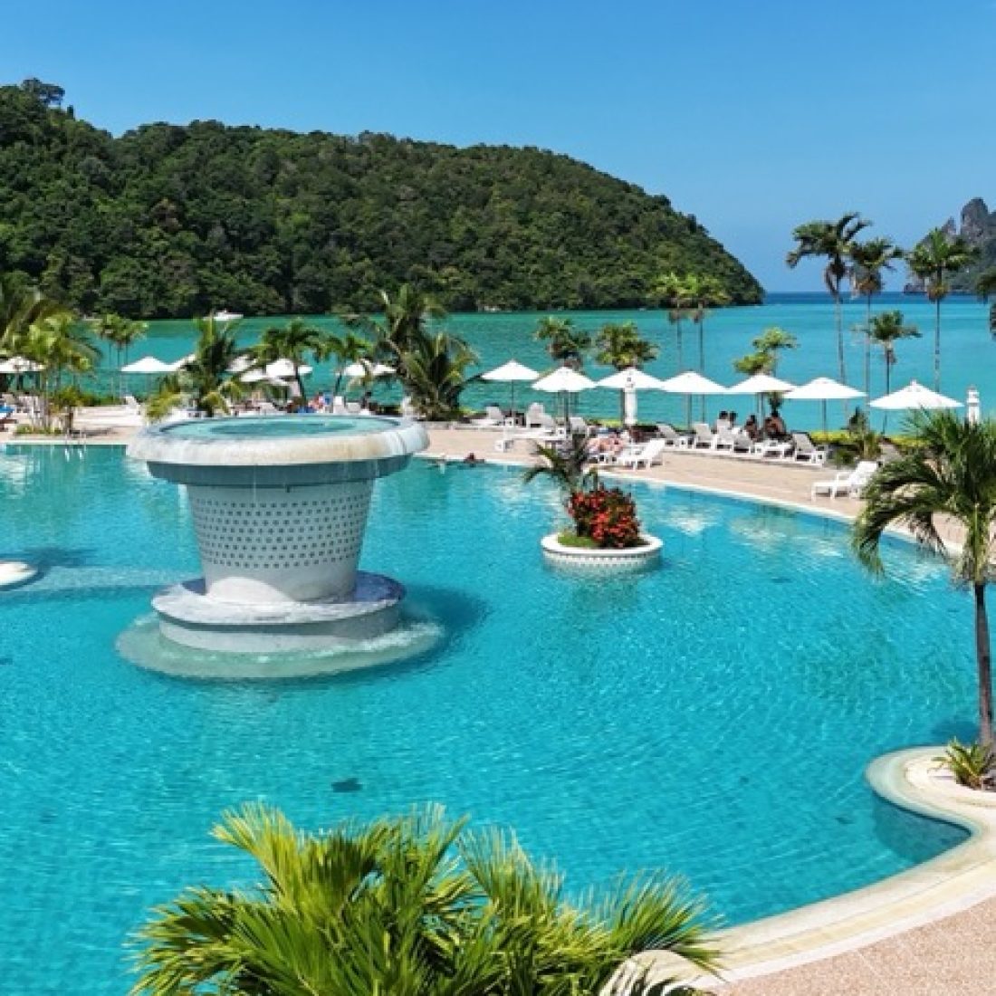 Hotel on Phi Phi Island in Thailand with beachfront views, turquoise water, and limestone cliffs in the background